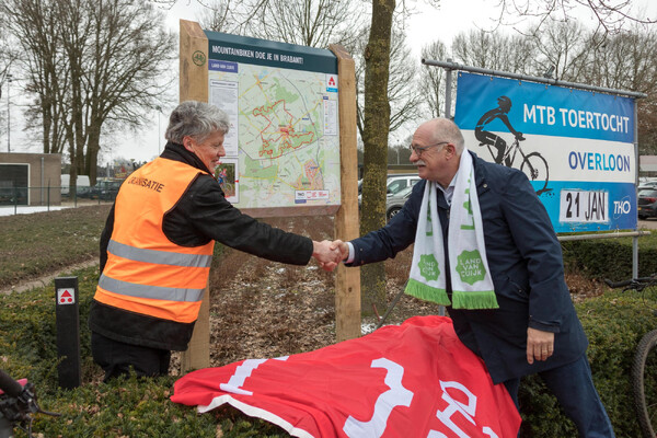 Wethouder Maarten Jilisen onthult informatiepaneel MTB-route van Toerklub Overloon in overloon